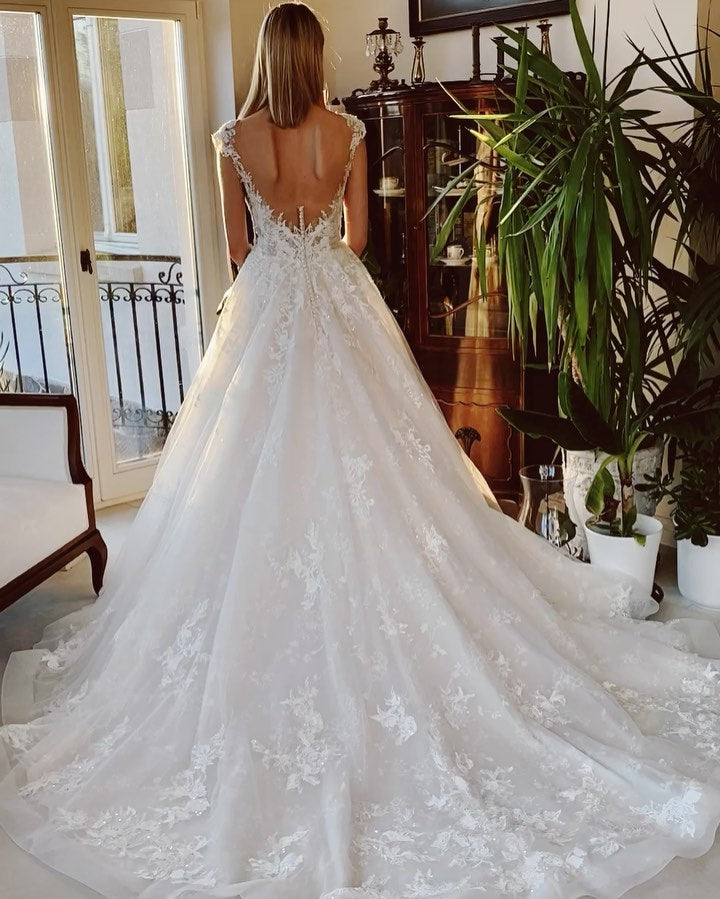 Ärmelloses Bateau-Brautkleid in A-Linie mit rückenfreier Kirchenschleppe und applizierter Spitze