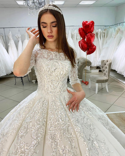 Wunderschönes bodenlanges Bateau-Brautkleid im Prinzessin-Stil aus Satin mit langen Ärmeln und Spitzenapplikationen